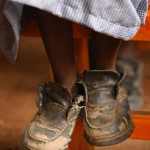 A child in beat-up shoes