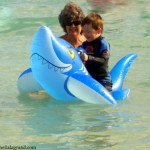child in ocean on inflatable shark